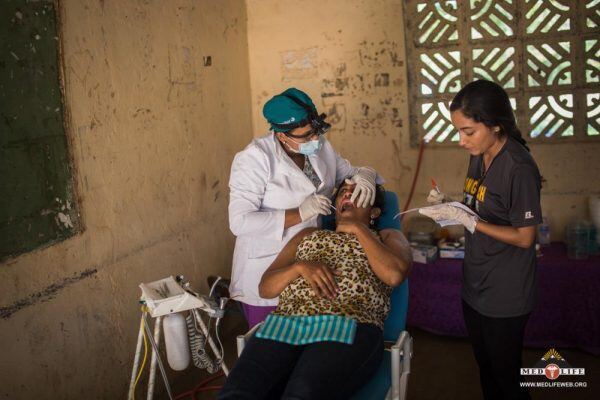 local dentist and pre dental volunteer assistant in mobile clinic